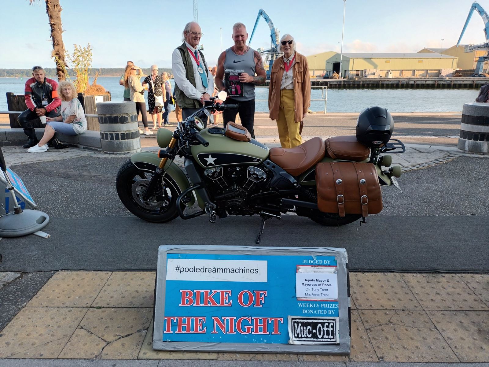3 men posing with a wining bike at Poole quay 